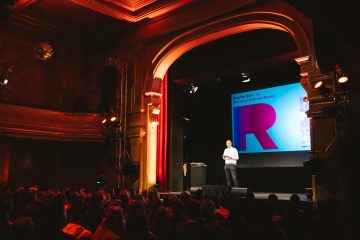 Veranstalter Jochen Markett auf der Bühne des Berlin-Neuköllner Heimathafens beim "Reporter Slam"-Jahresfinale im januar 2024. Foto: Vic Harster